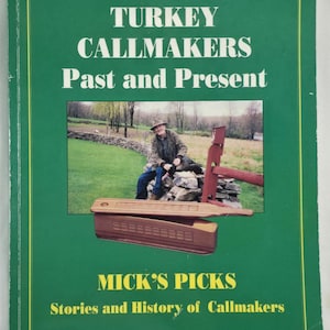Op de afbeelding: Een groene boekomslag met de titel "TURKEY CALLMAKERS Past and Present" in witte tekst. De omslag bevat een foto van een man en een kalkoenroeper. De tekst "MICK'S PICKS" is ook zichtbaar.