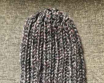 May include: A gray and pink knitted beanie hat with a ribbed texture.