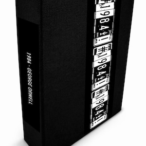May include: A black hardcover book titled "1984" by George Orwell. The spine features a vertical band with white license plate-style graphics. The book's title and author are printed in white on the spine.