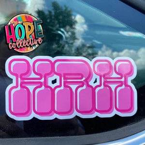 Könnte beinhalten: Rosa-weißer Vinyl-Aufkleber mit dem Wort "GIRL" in einer stilisierten Schriftart. Der Aufkleber befindet sich auf einer Autoscheibe.