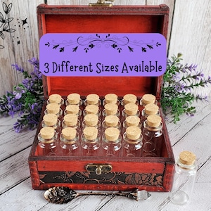 May include: A wooden box with a red velvet interior and a hinged lid. The box contains 24 small glass bottles with cork tops. The box has a label that reads "3 Different Sizes Available".
