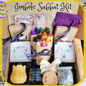 May include: A box filled with items for an Imbolc Sabbat kit. The box contains candles, a purple pouch, a bracelet, a necklace, a key, a jar of herbs, a candle in the shape of a tulip, and a small book. The box is labeled "Imbolc Sabbat Kit".