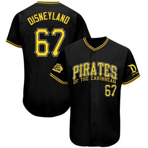 May include: Black baseball jersey with yellow accents. The jersey features the text "DISNEYLAND" and the number "67" on the back. The front displays "PIRATES OF THE CARIBBEAN" and the number "67". A small "D" logo is on the sleeve.
