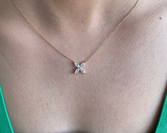 May include: A delicate gold chain necklace with a small, four-pointed star pendant set with clear diamonds.
