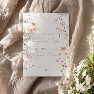 Puede incluir: Tarjeta de guardar la fecha con ilustraciones florales de acuarela. La tarjeta dice "Save the Date, Henry y Evelyn, 30 de junio de 2023, cuatro en punto de la tarde, 123 Anywhere st, Any City, St 12345."