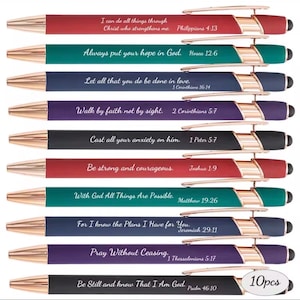 May include: A set of ten retractable ballpoint pens in various colors including red, teal, navy, purple, and black. Each pen features rose gold accents, a stylus tip, and a unique Bible verse printed in white script text along the barrel.