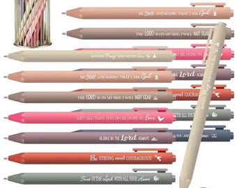 May include: A collection of pastel-colored pens with inspirational quotes, including "Always Pray, and Never Give Up" and "Be Strong and Courageous!" The pens are displayed in a metal wire holder and individually. The pens are approximately 5.5 inches long.