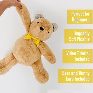 Pu&ograve; includere: Un orsacchiotto di peluche marrone con un fiocco giallo e orecchie floreali. L'orso &egrave; tenuto sollevato da una mano. Il testo "Perfetto per i principianti", "Peluche morbido e coccoloso", "Tutorial video incluso" e "Orecchie di orso e coniglio incluse" &egrave; scritto in scatole gialle.