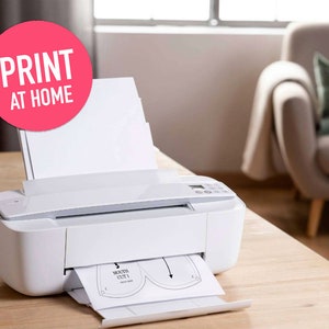 Pu&ograve; includere: Una stampante a getto d'inchiostro bianca con una grafica circolare rosa contenente il testo bianco PRINT AT HOME. La stampante ha una risma di carta bianca nel vassoio posteriore e un foglio stampato con il motivo MOUTH CUT 1 davanti.