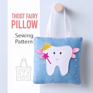 Puede incluir: Una almohada azul para el hada de los dientes con un diseño de diente blanco, una corona dorada y una varita rosa. La almohada tiene un asa blanca y el texto "THOOT FAIRY PILLOW Sewing Pattern".