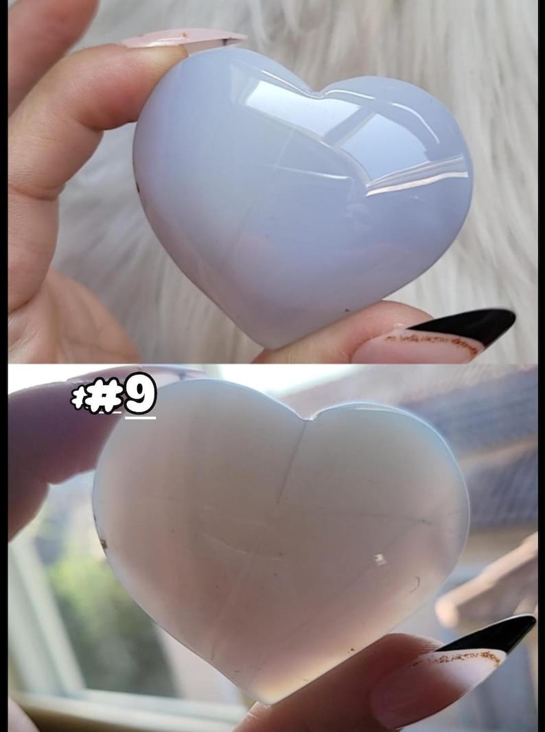 May include: Two heart-shaped stones are shown, one light blue and the other off-white. The stones are smooth and polished, with a glossy finish. The top stone is held by a hand with a light pink nail. The bottom stone has the number "#9" in the upper left corner.