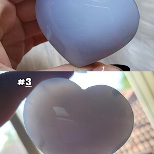May include: Two heart-shaped stones in the image. The top stone is a light blue color, and the bottom stone is a lighter shade of blue. The stones are smooth and polished. The number "#3" is visible on the bottom image.
