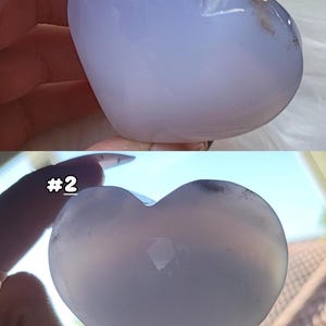 May include: Two heart-shaped stones, one light blue and the other a translucent white. The light blue heart has a slight gradient, with darker blue at the top and fading to white. The second heart is translucent with the number "#2" in the image.