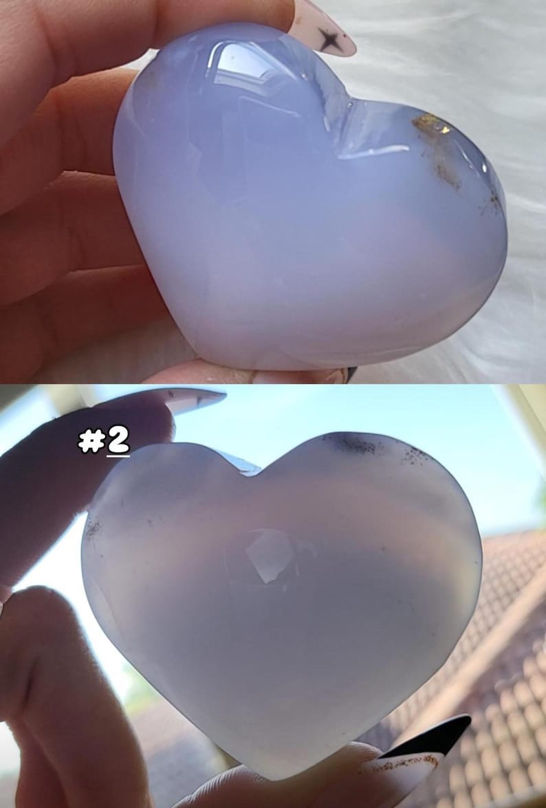 May include: Two heart-shaped stones, one light blue and the other a translucent white. The light blue heart has a slight gradient, with darker blue at the top and fading to white. The second heart is translucent with the number "#2" in the image.
