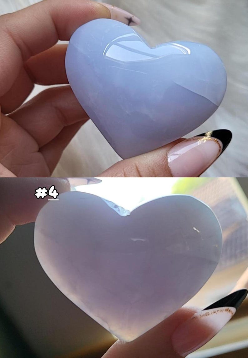 May include: Two heart-shaped stones, one light blue and the other a pale lavender, are held in hands. The light blue stone is more translucent. The stones are smooth and polished, with a glossy finish. The image includes the text "#4".