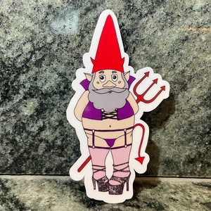 May include: A red and white gnome with a purple and black outfit, holding a red trident and a red tail. The gnome is wearing pink stockings and black heels.