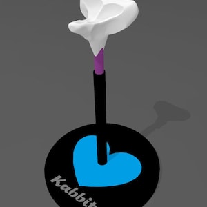 Puede incluir: Un diseño de monociclo caprichoso con una parte superior blanca, un tallo morado y negro, y una rueda negra con un corazón azul y la palabra "Kabbit". El diseño está sobre un fondo gris.