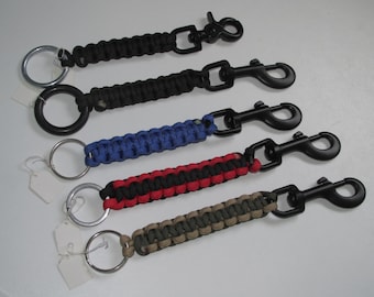 Puede incluir: Cinco llaveros de paracord en negro, azul, rojo y negro, y verde oliva y marrón. Cada llavero tiene un anillo de metal y un clip de metal negro. Se adjuntan etiquetas en blanco.
