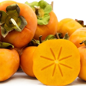May include: A cluster of vibrant orange persimmons with green leafy calyxes, including one fruit sliced in half to reveal a star-shaped pattern in the center of the smooth, firm flesh. The fruits are round and glossy, showcasing a bright orange hue.