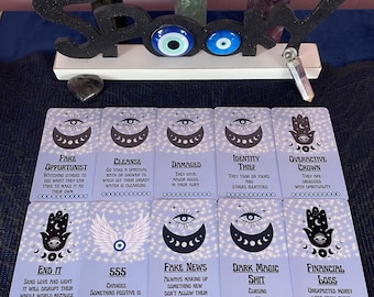 May include: A set of ten tarot cards with a blue and white background. Each card features a black and white illustration of an eye, a crescent moon, and a hand. The cards are labeled with phrases such as "Fake Opportunist", "Cleanse", "Damaged", "Identity Thief", "Overactive Crown", "End It", "555", "Fake News", "Dark Magic Shit", and "Financial Loss".