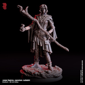 May include: A painted miniature figurine of a female character with long brown hair, wearing a brown robe and holding a staff with a twisted branch. The figurine is standing on a rocky base. The text "Anna Santos, Apostate Animist" and "Medium - 25 mm base" is visible below the figurine.