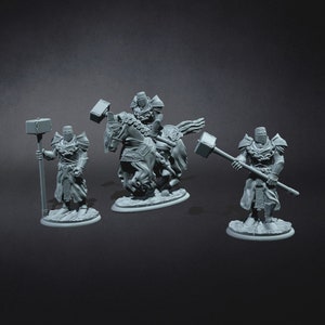 May include: Three miniature figures of knights, one on horseback, all holding large hammers. The figures are painted in a grey colour and are posed in a dynamic action stance.