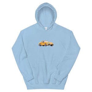 Pode incluir: Um moletom azul claro com um carro amarelo bordado na frente.