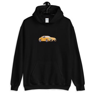 Pode incluir: Um moletom preto com um gr&aacute;fico de um carro amarelo na frente. O carro &eacute; um carro esportivo com um perfil baixo e um design elegante.