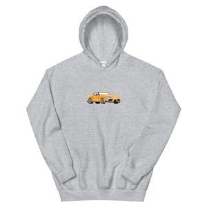 Pode incluir: Um moletom cinza com um carro amarelo bordado na frente. O carro &eacute; um carro esportivo com interior preto.