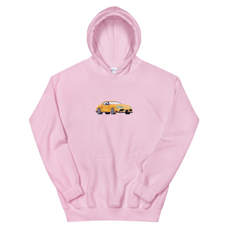 Pode incluir: Um moletom rosa com um carro amarelo bordado na frente.