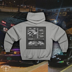 Puede incluir: Sudadera con capucha gris con un estampado gráfico de un coche Mercedes Benz Evo II en la espalda. El gráfico es en blanco y negro y presenta un patrón de cuadrícula.