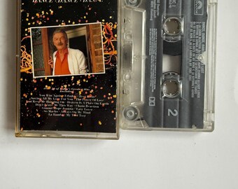 May include: A vintage cassette tape of James Last's album "Dance, Dance, Dance." The cassette case features a photo of James Last and the album title. The tape is clear, and the label includes song titles.