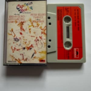 以下が含まれることがあります： 赤いラベルとグレーのボディのヴィンテージオーディオカセットテープ。カセットケースには、アーティストの名前とともに「Captain Beaky」のタイトルが記載されています。ケースはカラフルな抽象的なデザインです。