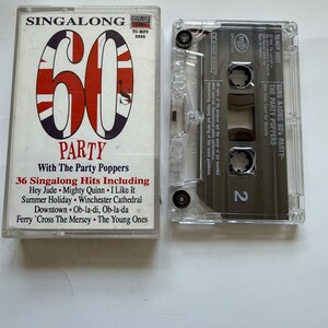 May include: A vintage cassette tape for "Singalong 60's Party" by The Party Poppers. The cassette case is clear, and the cover features a large "60" with a Union Jack design. The tracklist includes hits like "Hey Jude" and "I Like It."