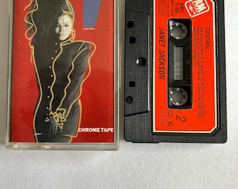 May include: A black cassette tape with a red label. The label has the text "CONTROL" and "JANET JACKSON" in white. The cassette tape is labeled "Chrome Tape" and has a price of 2.00 Euros.