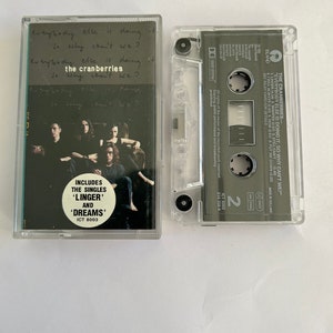 May include: A cassette tape of the album "Everybody Else Is Doing It, So Why Can't We?" by The Cranberries. The album cover features a black and white photo of the band members. The cassette tape is clear plastic with a black label. The label includes the album title, band name, and track list. The cassette tape is in a clear plastic case.