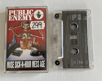 May include: A cassette tape of Public Enemy's album "Muse Sick-N-Hour Mess Age". The cassette tape is in a clear plastic case with a black label. The label has the album title, artist name, and record label information. The cassette tape is next to the album cover art, which features a skeleton wearing a hat and holding a bottle of liquor. The album cover art is red, white, and black.
