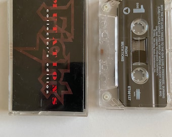 May include: A black cassette tape with a red and black graphic of the band "Fight" and the text "Mutations collector's edition". The cassette tape is in a clear plastic case.
