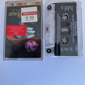 May include: A cassette tape of the album "The Very Best of Crowded House" by Recurring Dream. The cassette tape is in a clear plastic case with a black label. The label has the band's name, album title, and a copyright notice. The cassette tape is priced at $9.99.