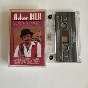Peut inclure: Une cassette audio Acker Bilk Love Songs avec une photo du musicien portant un chapeau et une clarinette. La cassette comprend les chansons Evergreen, Sailing, Without You, Song for Guy et Together We Are Beautiful.
