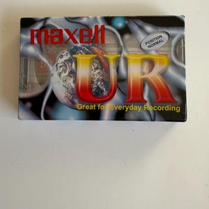 May include: A Maxell UR audio cassette tape with a colorful design featuring a globe and the text "Great for Everyday Recording".