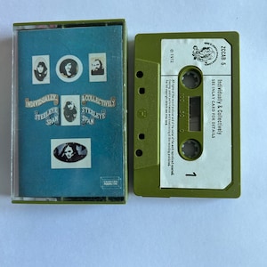 Può includere: Un nastro per cassette verde con il titolo "Individually & Collectively" di Steelye Span. Il nastro per cassette è etichettato con il numero "ZCCAB 5" e l'anno di copyright "1972".