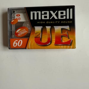 May include: A Maxell brand audio cassette tape with a red and orange design. The tape is labeled "High Quality Sound" and "UE 60".