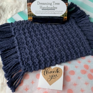 May include: A navy blue knitted coaster with fringe, a business card holder with business cards that read "Dreaming Tree Handmades", and a "thank you" sticker on a pink and white polka dot wrapping paper.