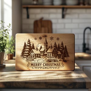 May include: A rectangular wooden cutting board with a laser-etched winter village scene. The design includes houses, trees, a church, and the words "MERRY CHRISTMAS". The board is displayed on a wooden surface.