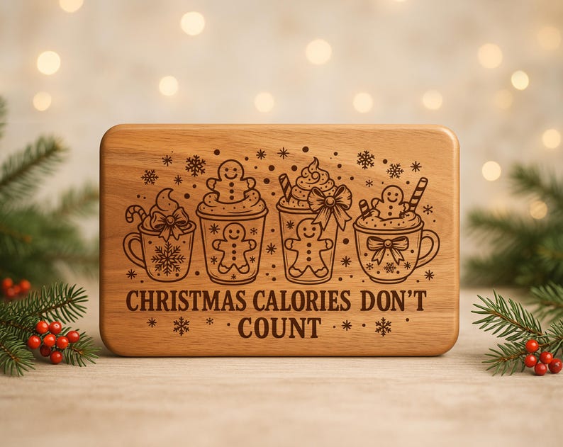 May include: A rectangular wooden cutting board with rounded corners. The board features engraved illustrations of four mugs with whipped cream, gingerbread men, and candy canes. The text "CHRISTMAS CALORIES DON'T COUNT" is also engraved.