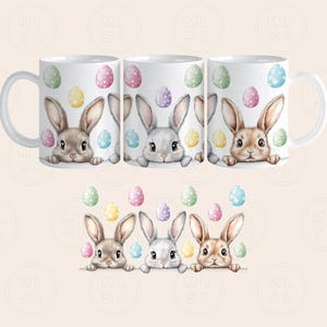 May include: Three white mugs with handles, each featuring a different bunny rabbit peeking over the rim. The bunnies are surrounded by colorful Easter eggs.