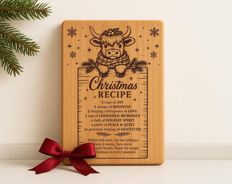 May include: A rectangular wooden cutting board with a carved design and text. The design features a cow wearing a scarf above the words "Christmas Recipe." The recipe includes ingredients like joy and kindness. A red bow is at the bottom.
