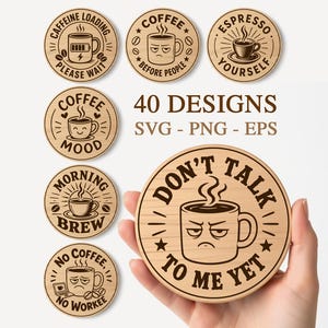 May include: A collection of wooden coffee-themed coasters with various designs. One coaster is held in a hand, featuring a grumpy coffee cup and the text "DON'T TALK TO ME YET." Other coasters have phrases like "Caffeine Loading" and "Espresso Yourself."