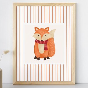 May include: A framed art print featuring a watercolor illustration of a cartoon fox. The fox is orange with a white chest and tail, wearing a red and white striped scarf. The background has vertical orange stripes.